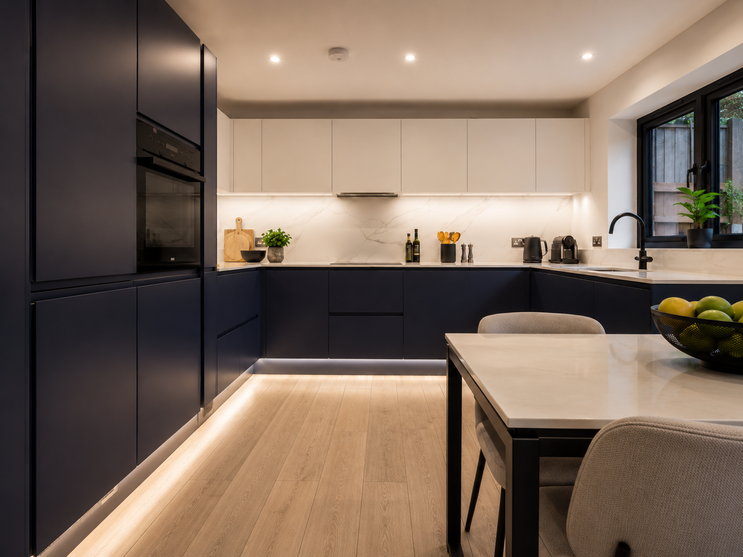 Matte navy handleless kitchen London with pale stone worktops — Dominus Kitchens