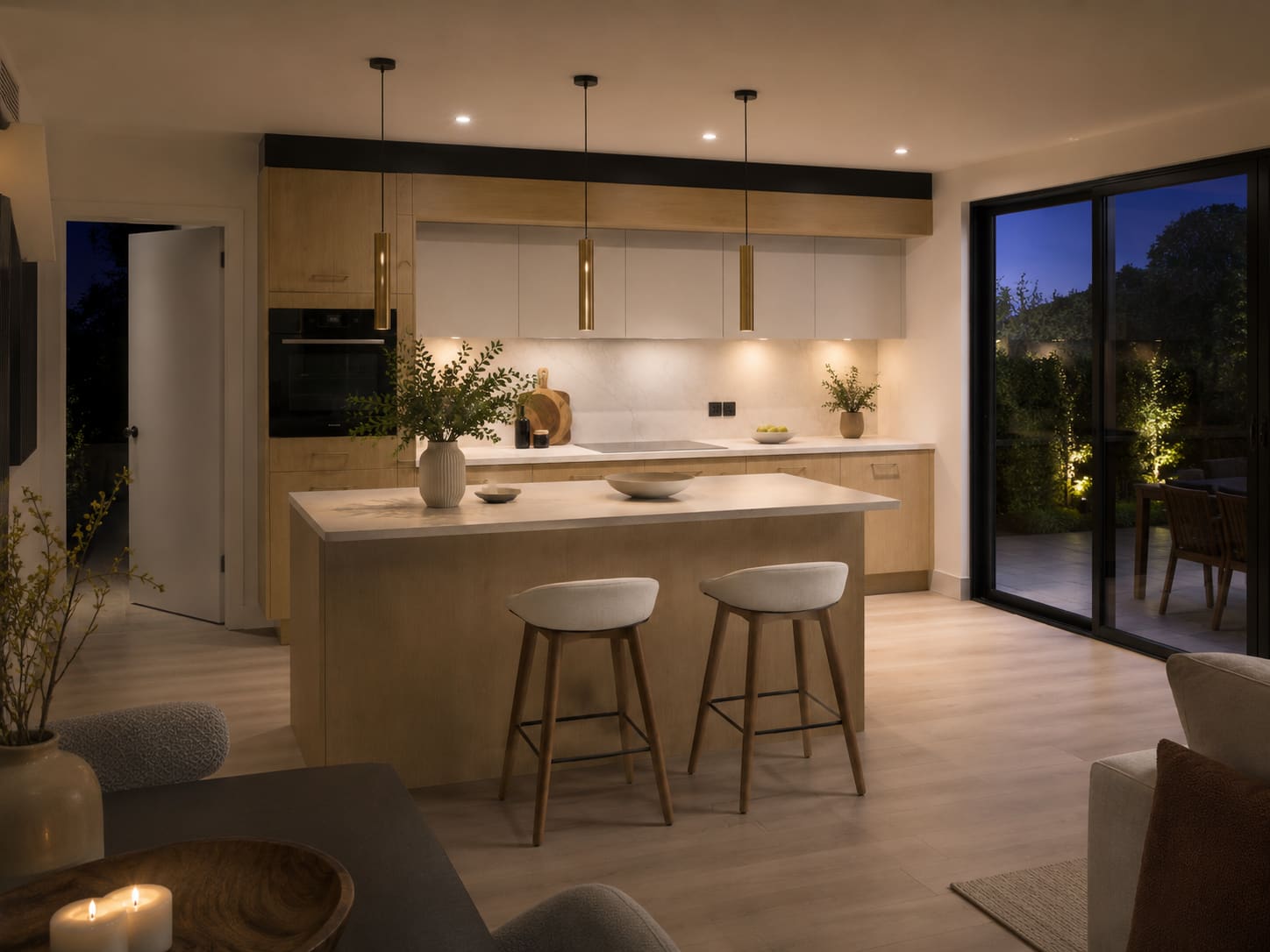 Night view of a related light oak bespoke kitchen with island and garden doors — Dominus Kitchens